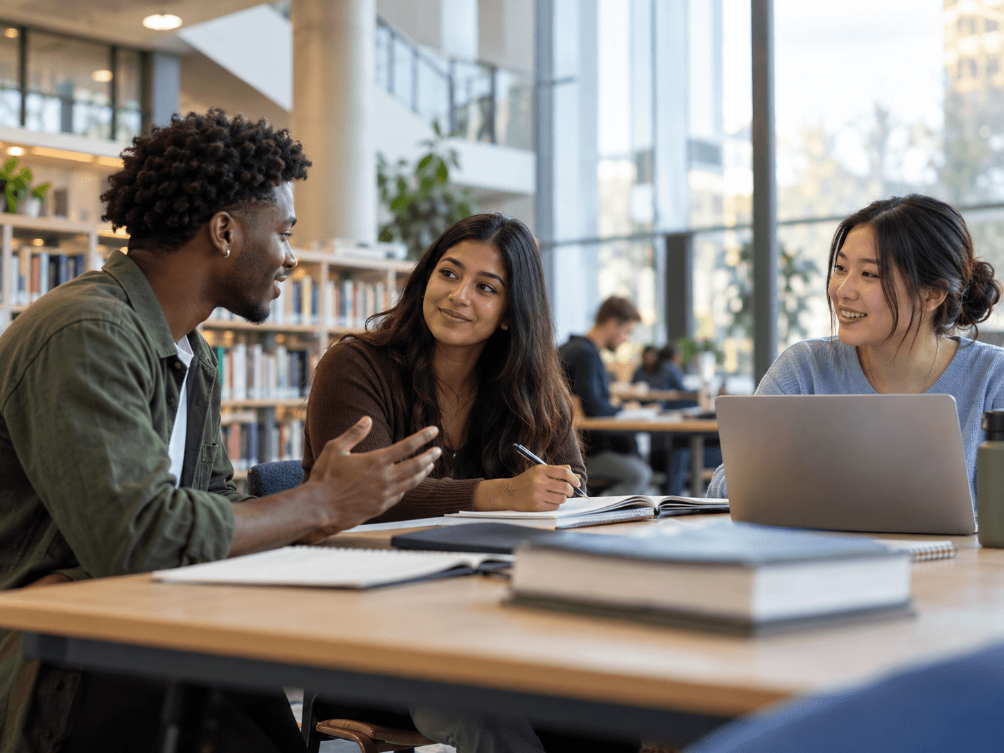 Adult learners discussing academic work together in a modern university library